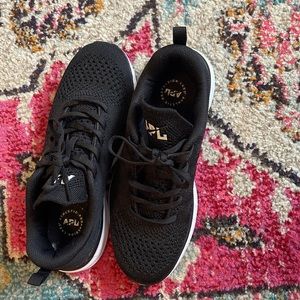 Athletic Propulsion Labs (APL) black sneakers.